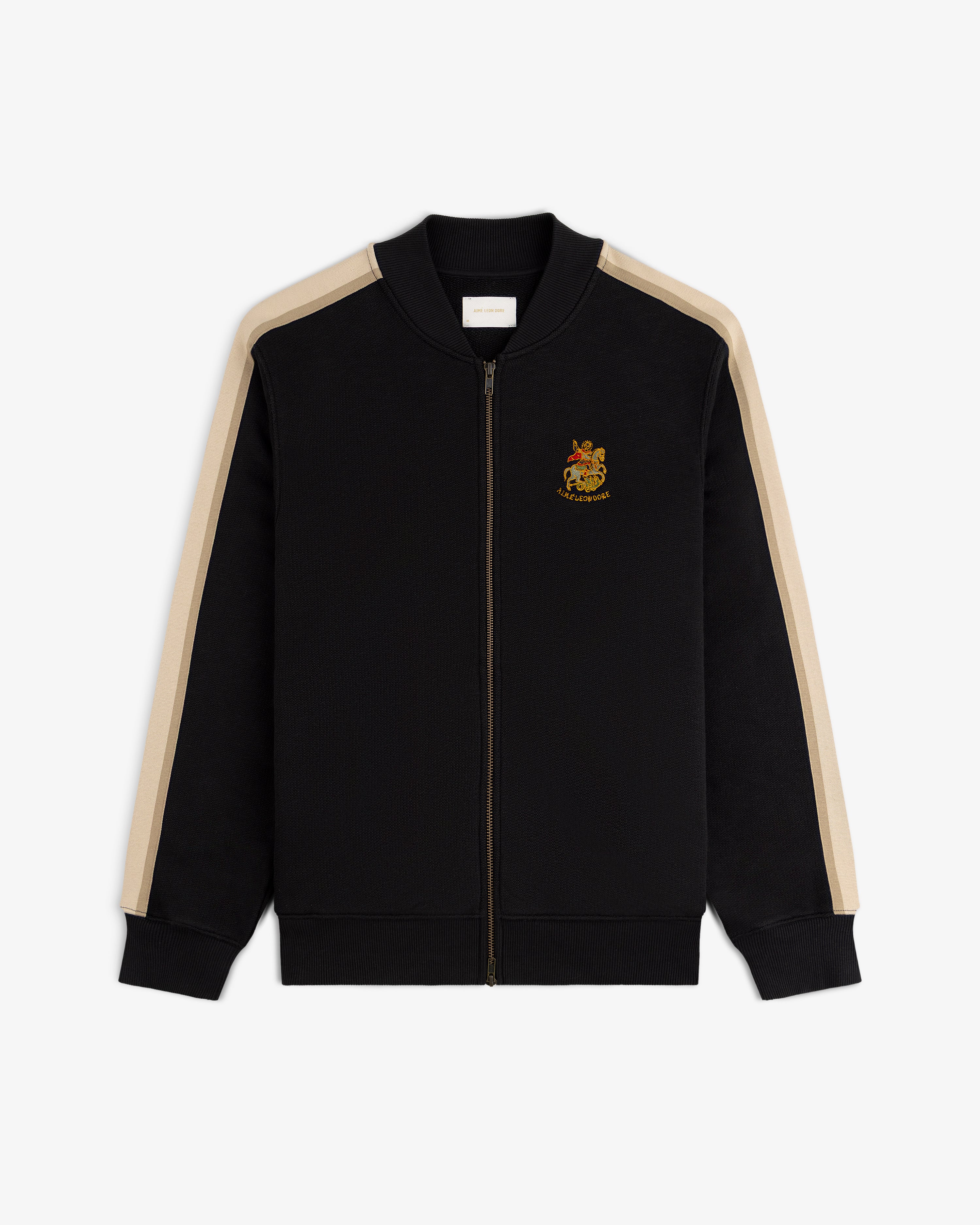 Saint George Track Jacket: black zip-up with beige sleeve stripes and an embroidered crest on the left chest.