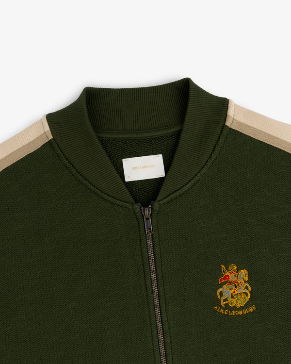 Saint George Track Jacket: Green zip-up with beige shoulder stripes & lion/AIME LEON DORE embroidered emblem.
