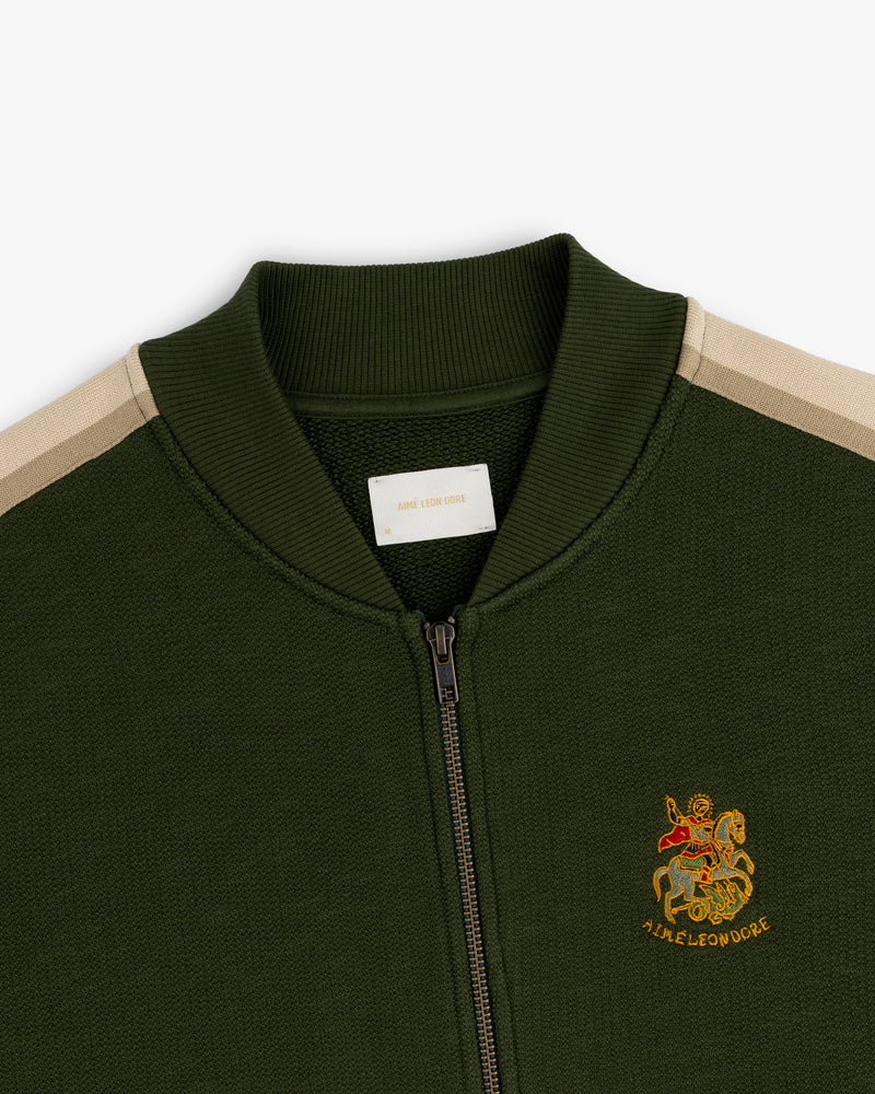 Saint George Track Jacket: Green zip-up with beige shoulder stripes & lion/AIME LEON DORE embroidered emblem.