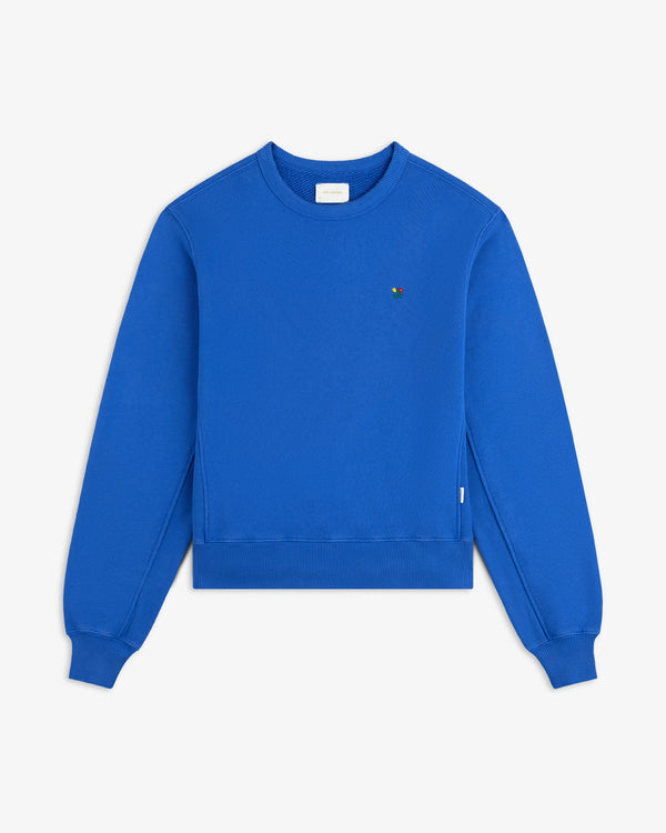 Bright blue Crest Crewneck Sweatshirt with a small, multicolored floral emblem on the chest.