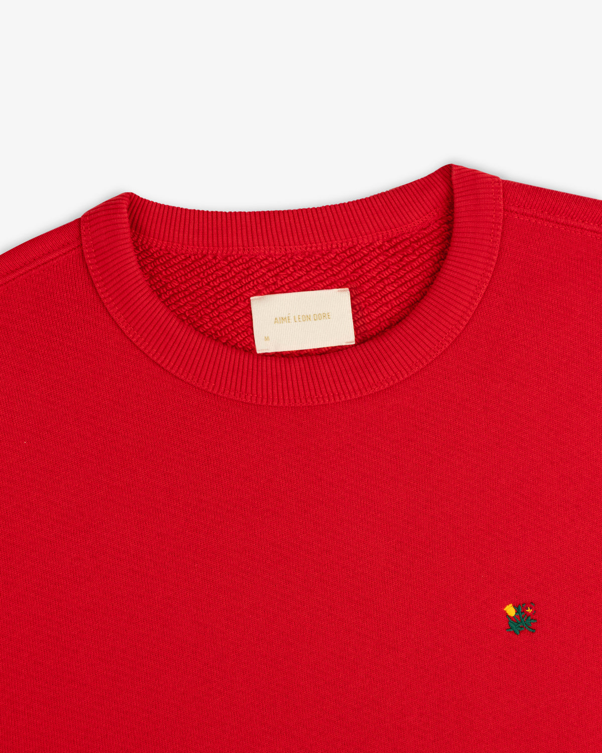 Red Crest Crewneck Sweatshirt with small floral chest embroidery and a brand label at the inner neckline.