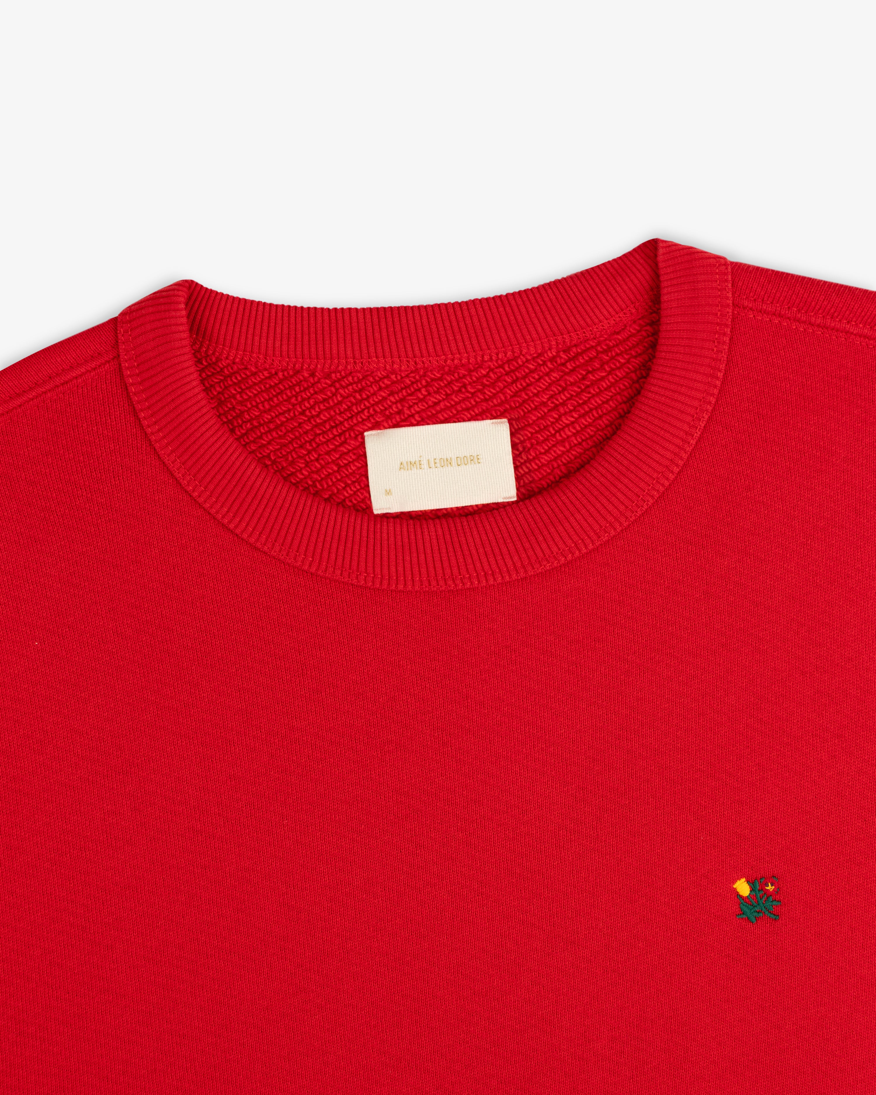 Red Crest Crewneck Sweatshirt with small floral chest embroidery and a brand label at the inner neckline.