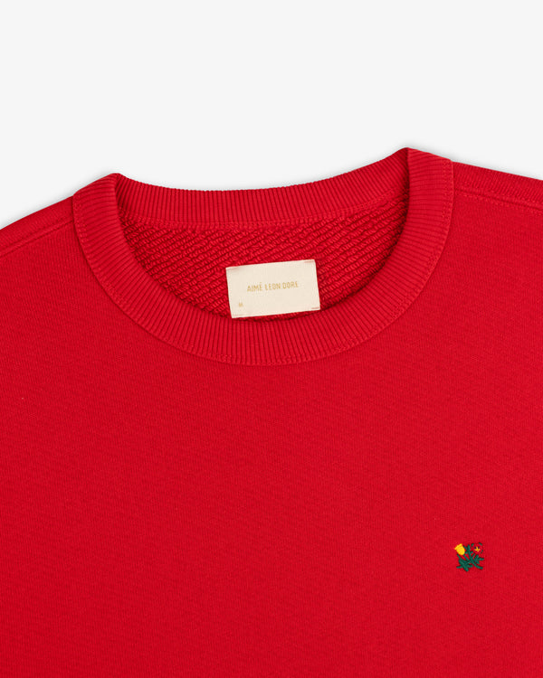 Red Crest Crewneck Sweatshirt with small floral chest embroidery and a brand label at the inner neckline.