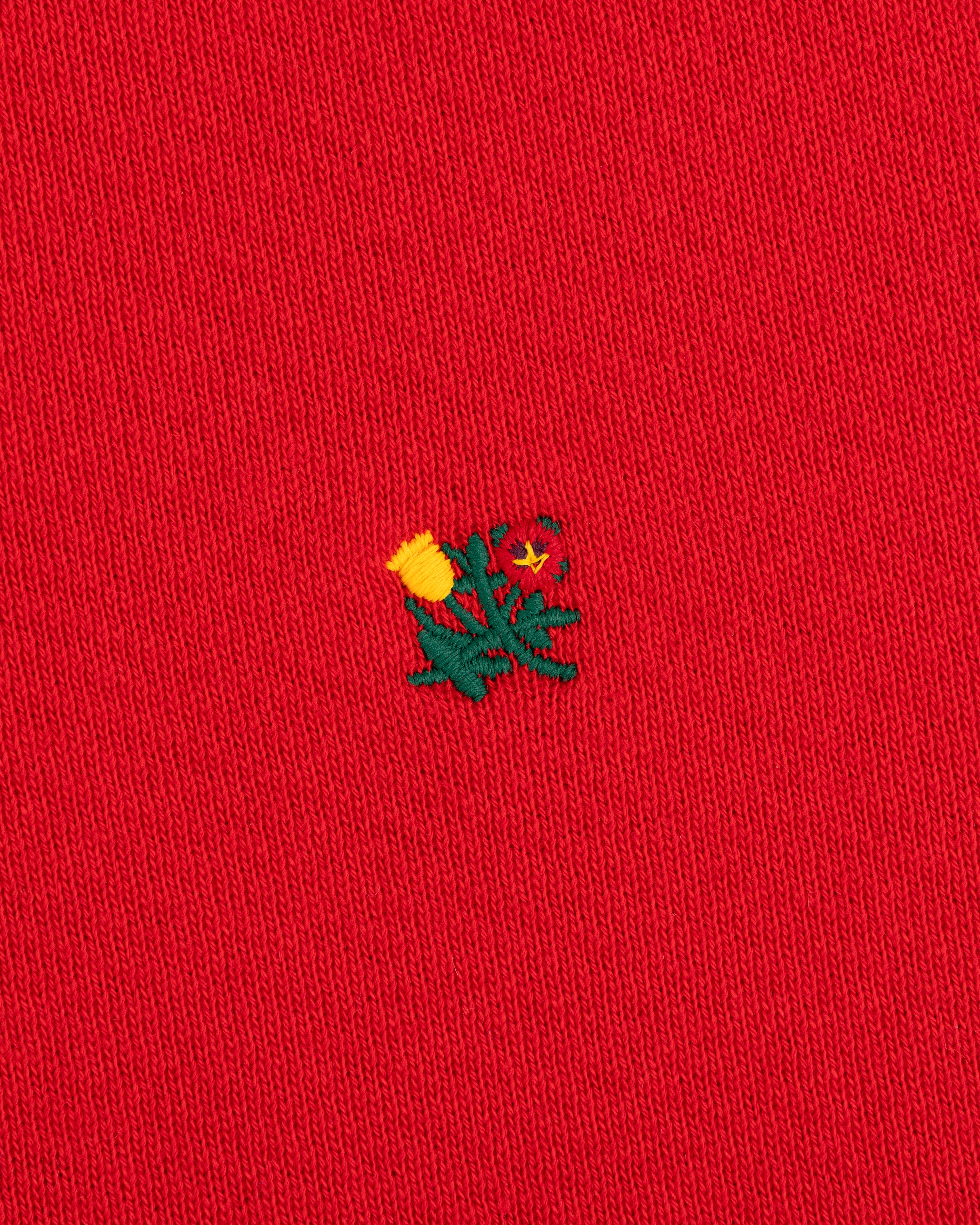 Crest Crewneck Sweatshirt in red fabric with a small embroidered yellow and green thistle design.