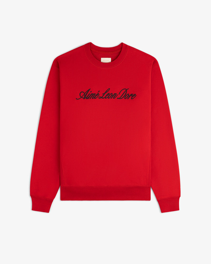 Vintage Script Crewneck Sweatshirt in red with black Aimé Leon Dore script, displayed flat on a white background.