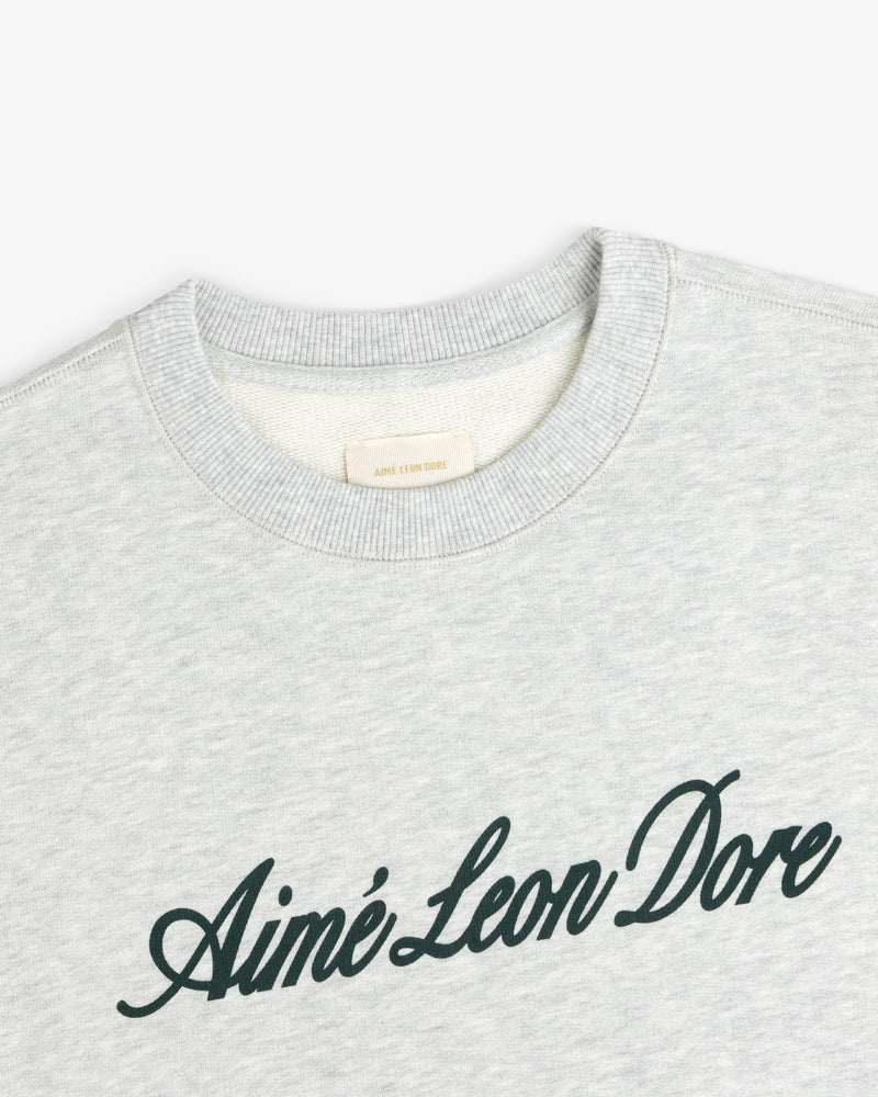 Light gray Vintage Script Crewneck Sweatshirt with Ainé Leon Dore in dark script across the chest.
