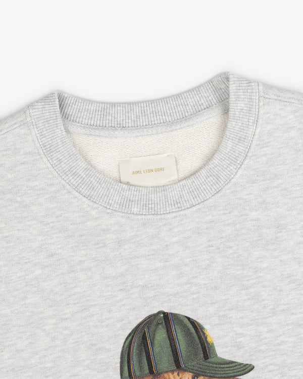 Buddy Crewneck Sweatshirt in light gray with neck tag and top of printed green cap design visible.