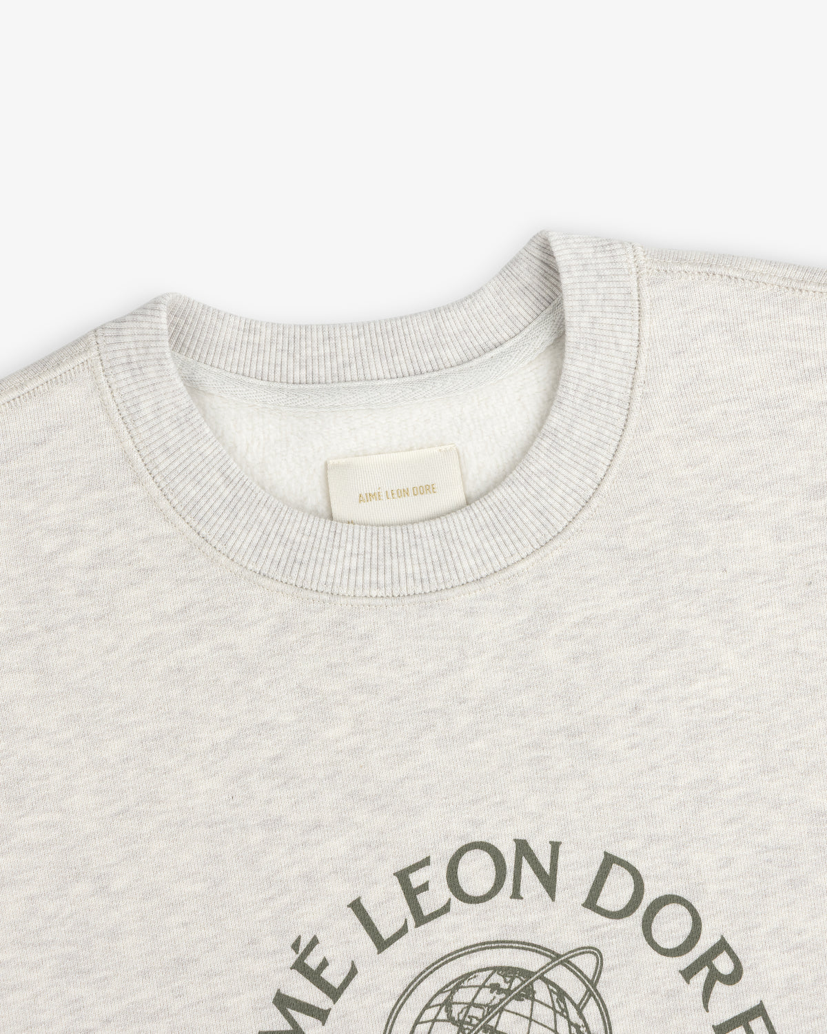 Close-up of a light gray Atlas Crewneck Sweatshirt with a circular graphic and interior brand label at the collar.