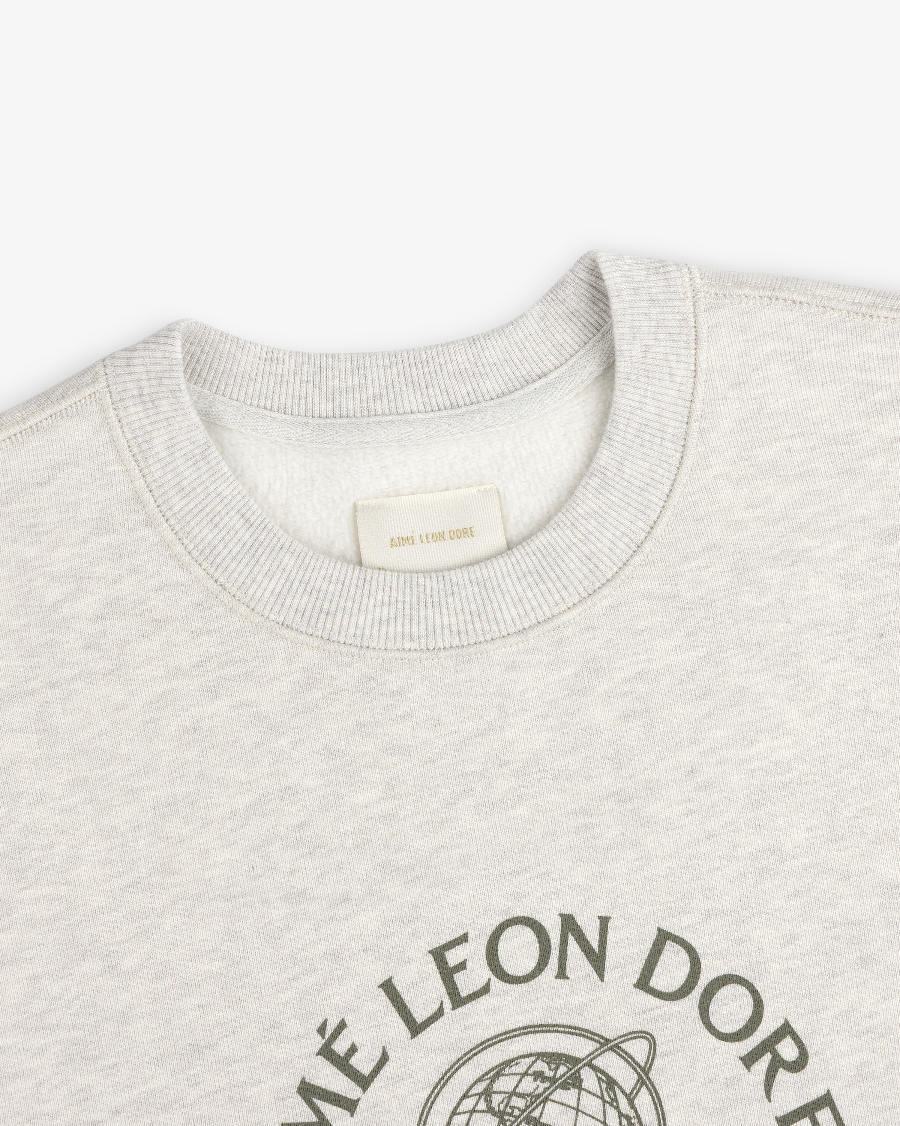 Close-up of a light gray Atlas Crewneck Sweatshirt with a circular graphic and interior brand label at the collar.