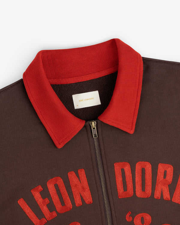 Chainstitch ’86 Half Zip Pullover in brown with a red ribbed collar and red embroidered text across the chest.