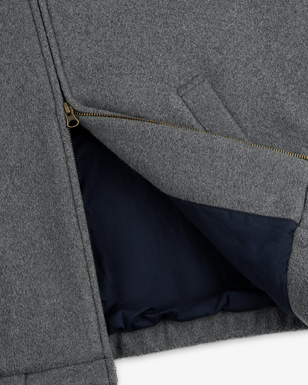 Close-up of the Crest Fleece Casual Jacket in gray with a brass zipper and dark navy lining visible inside.