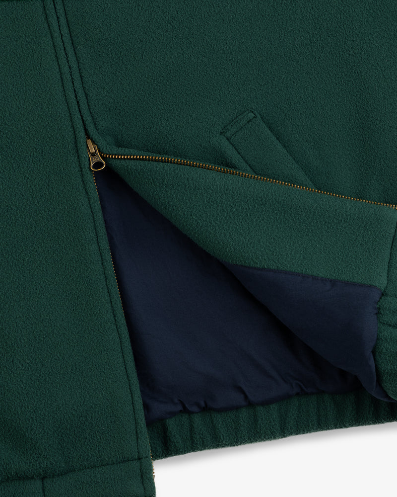 Close-up of the Crest Fleece Casual Jacket in green, featuring a brass zipper and navy blue lining.