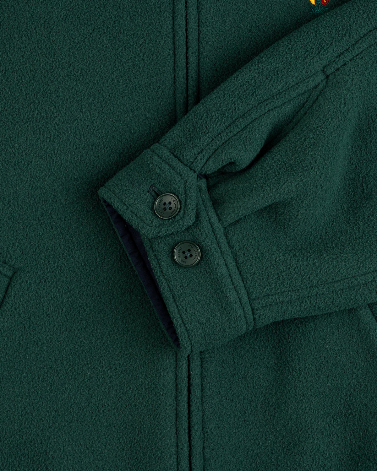 Crest Fleece Casual Jacket in dark green, featuring black buttons, visible seams, and partial pocket detail.