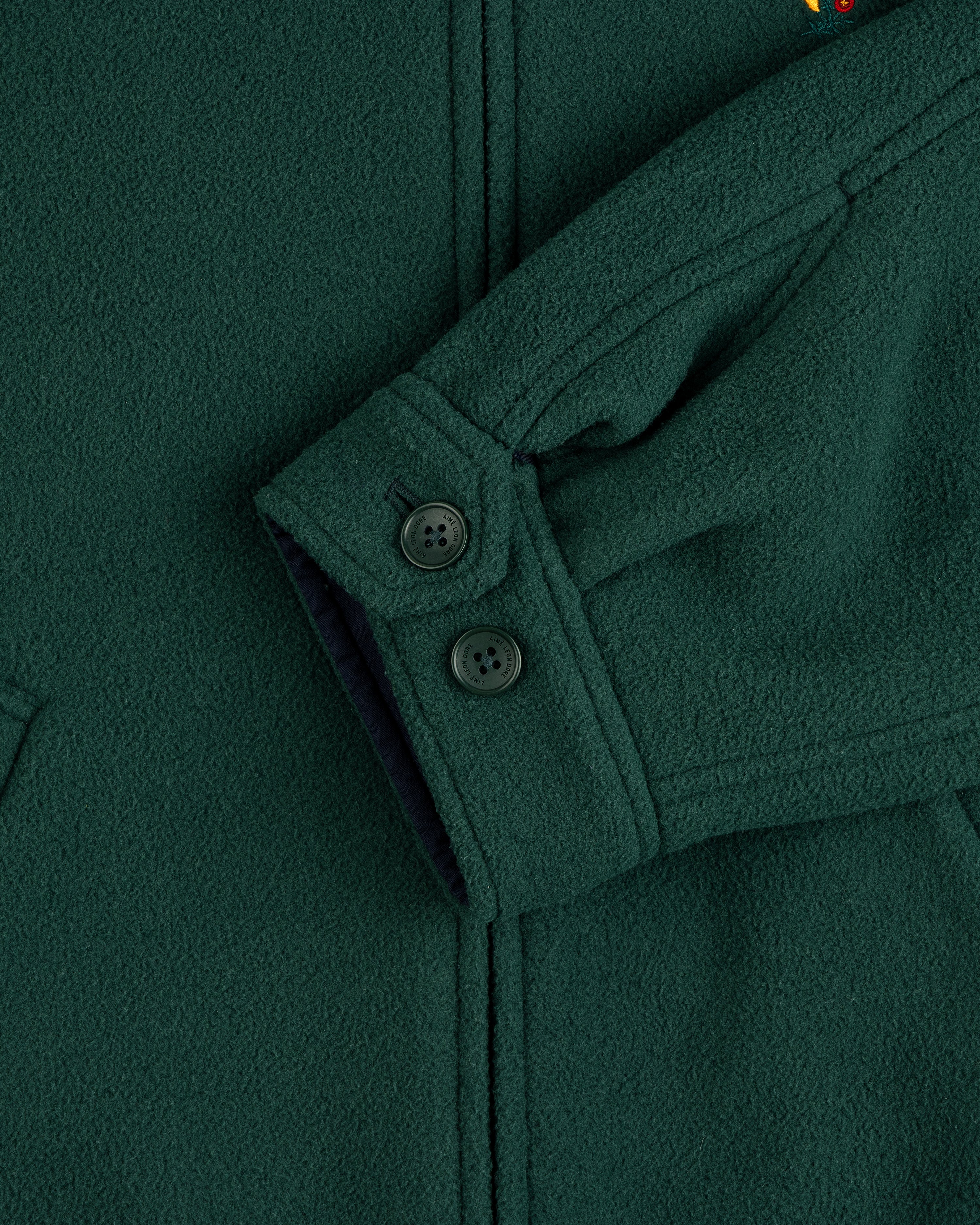 Crest Fleece Casual Jacket in dark green, featuring black buttons, visible seams, and partial pocket detail.