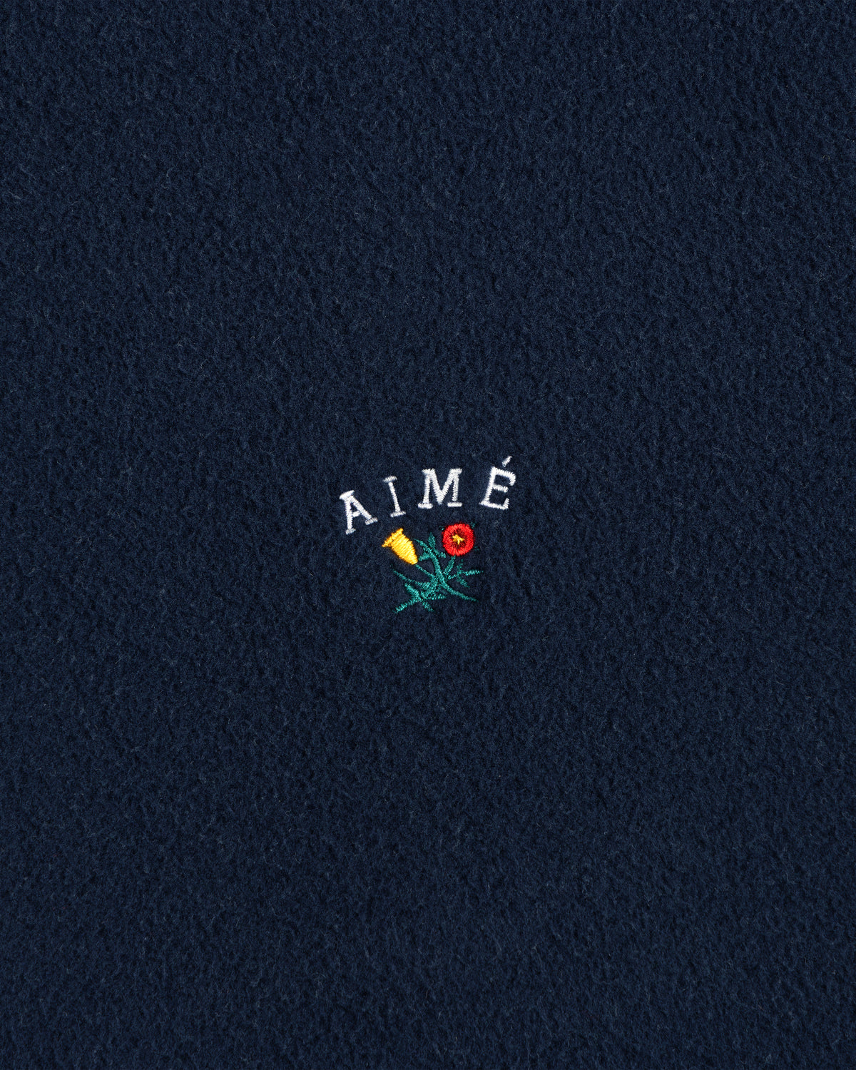 Navy Crest Fleece Casual Jacket with AIMÉ embroidered above a yellow and red flower on the center.