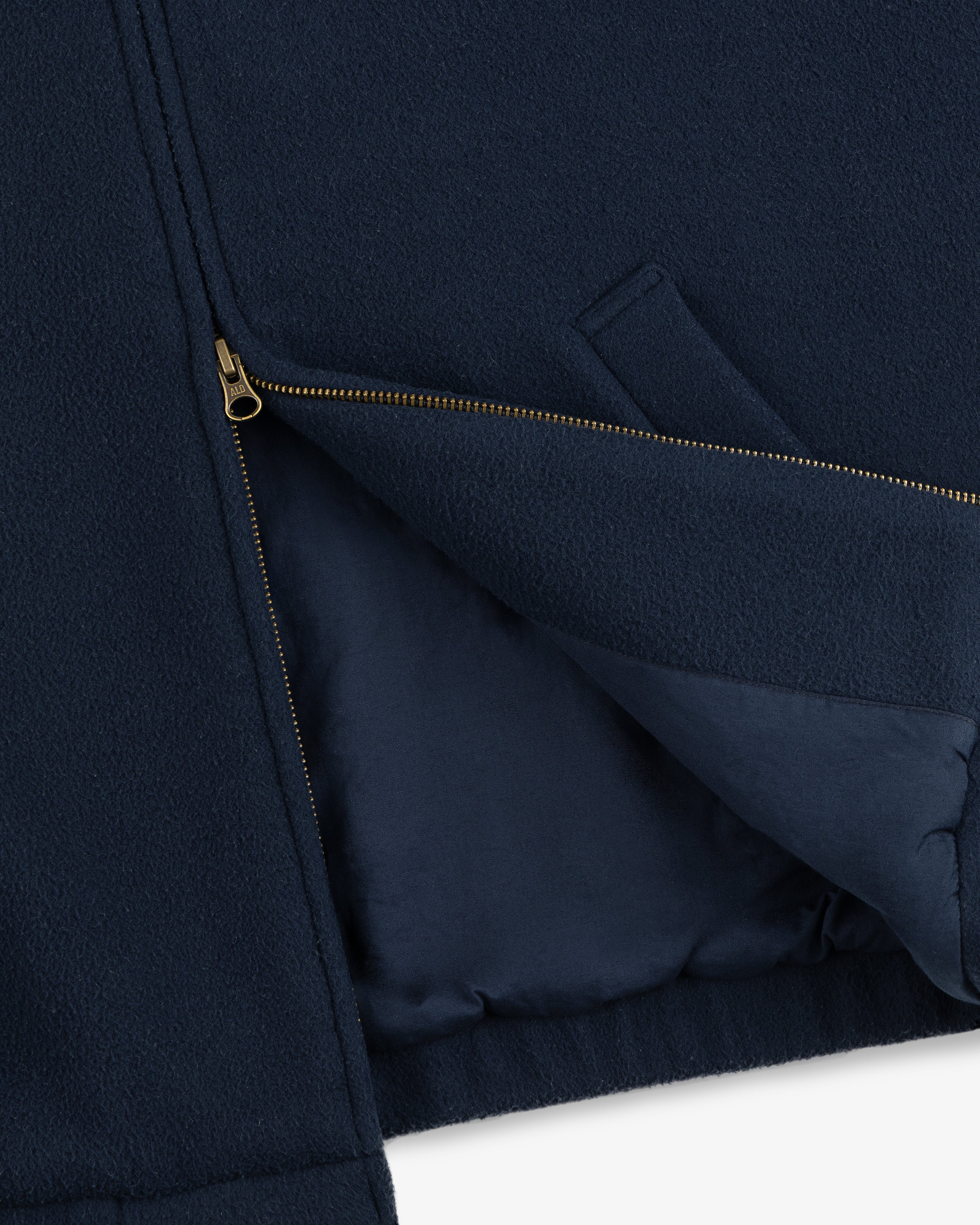 Close-up of the Crest Fleece Casual Jacket in navy with a gold zipper partially unzipped and side pocket visible.