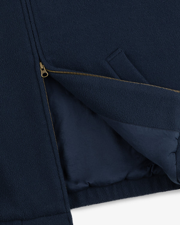 Close-up of the Crest Fleece Casual Jacket in navy with a gold zipper partially unzipped and side pocket visible.