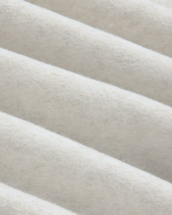 Close-up of beige fleece fabric with diagonal folds on a Surplus Fleece Quarter Zip Pullover.
