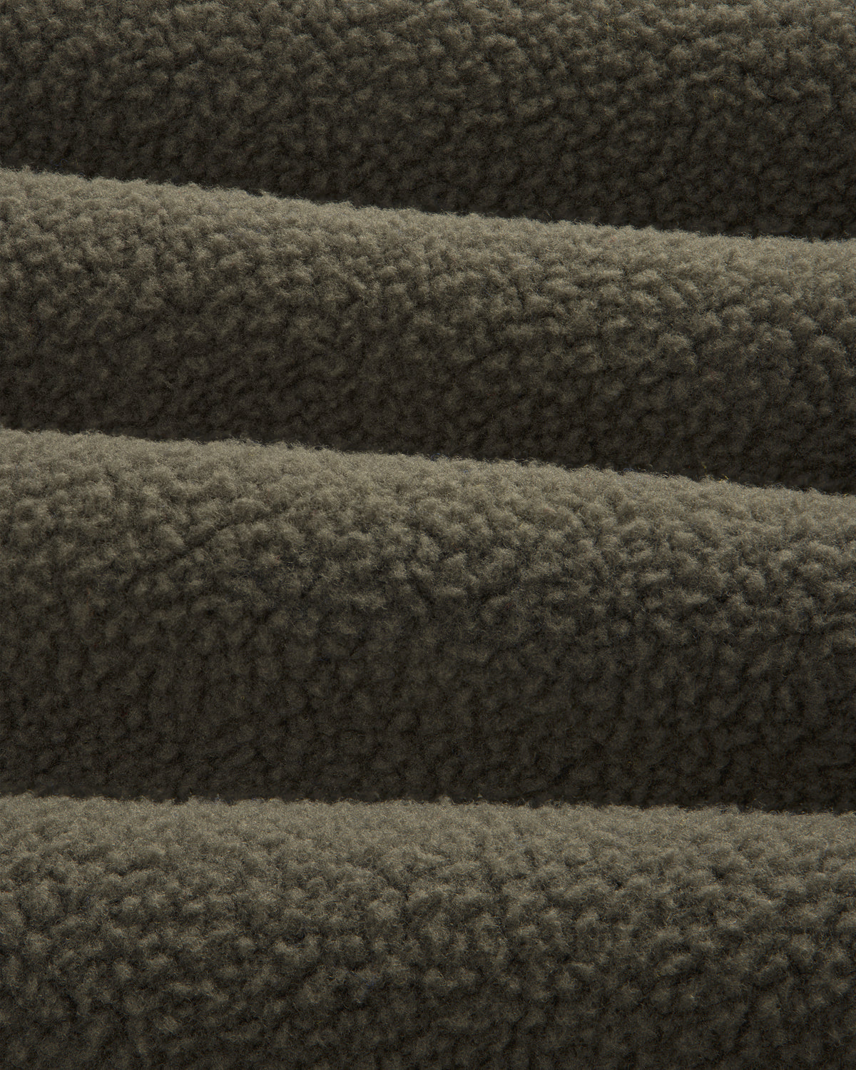 Close-up of ALD / The North Face Fleece Rugby, showing its soft, textured dark brown fleece in horizontal folds.