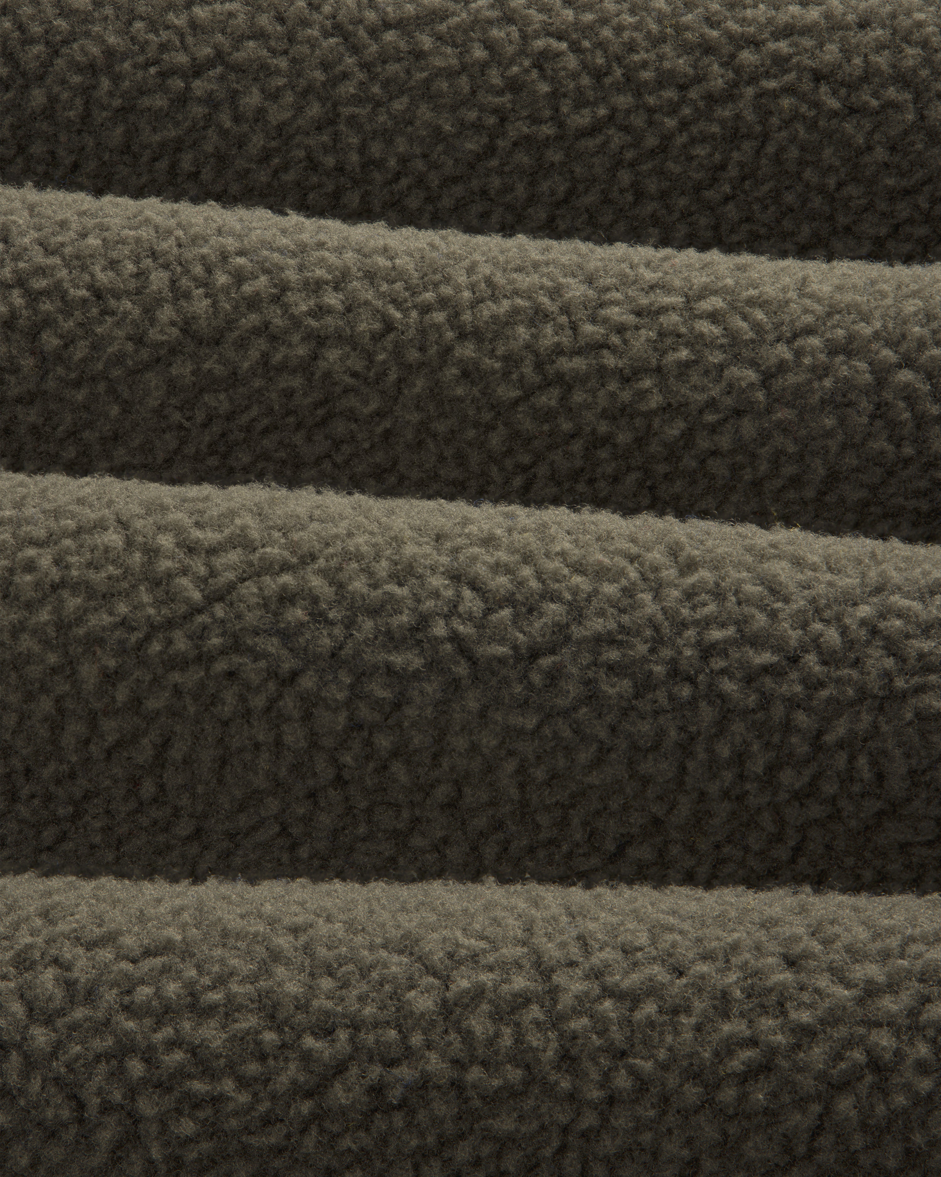Close-up of ALD / The North Face Fleece Rugby, showing its soft, textured dark brown fleece in horizontal folds.