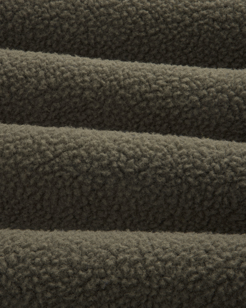 Close-up of ALD / The North Face Fleece Rugby, showing its soft, textured dark brown fleece in horizontal folds.