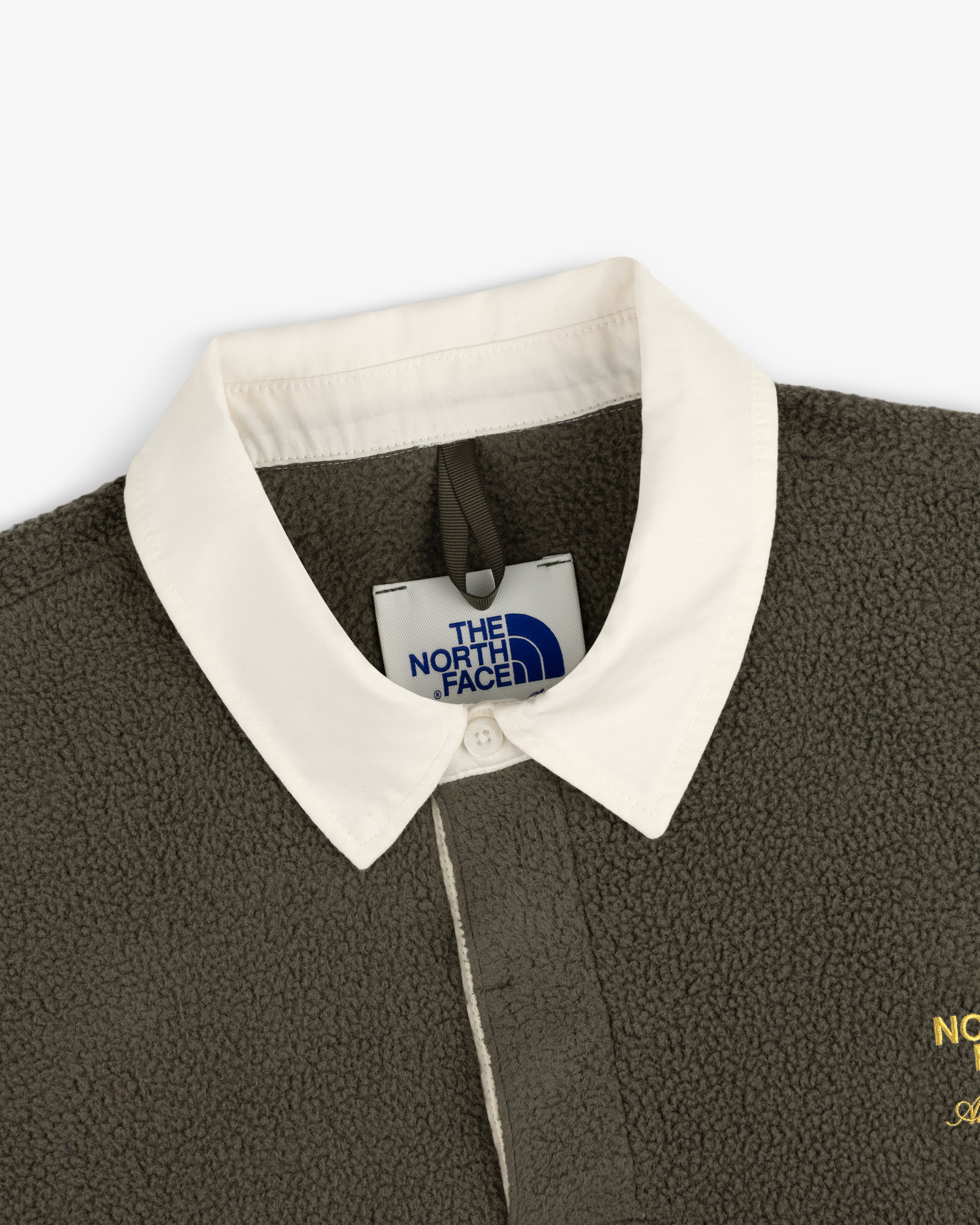 Close-up of the ALD / The North Face Fleece Rugby, featuring a white collar and interior brand tag.