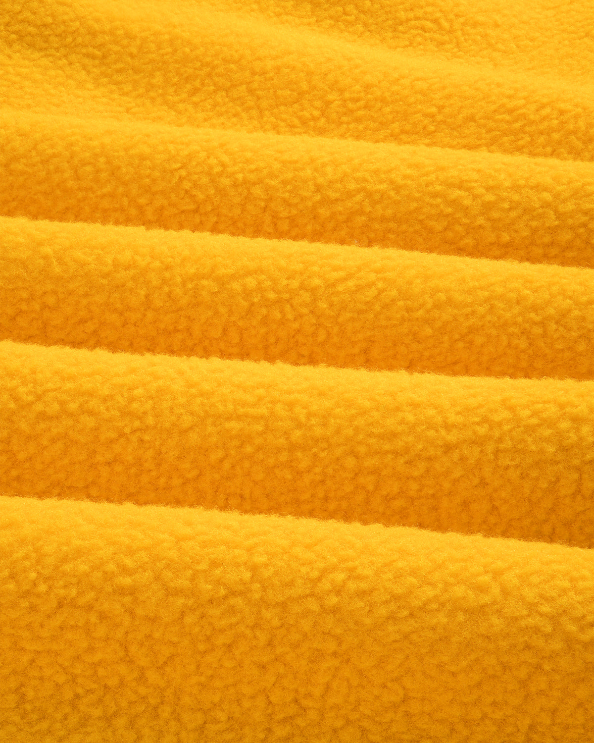 Close-up of soft yellow ALD/The North Face Fleece Rugby, showing textured horizontal folds in the fabric.