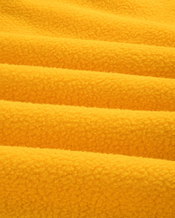 Close-up of soft yellow ALD/The North Face Fleece Rugby, showing textured horizontal folds in the fabric.