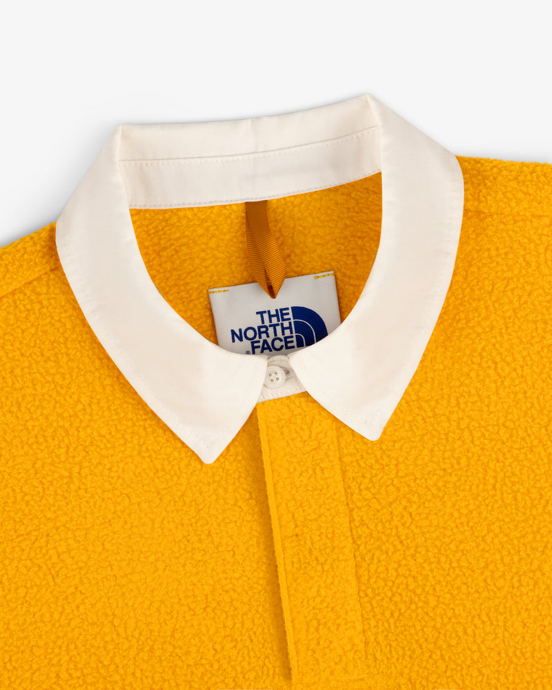 Close-up of ALD / The North Face Fleece Rugby in yellow with a white collar and visible interior label.
