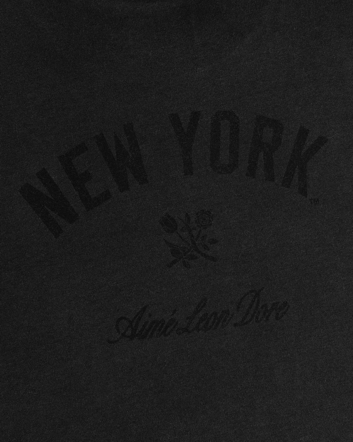 Black tee with arched NEW YORK, small rose, and cursive Aimé Leon Dore text. Yankees Washed Logo Tee.