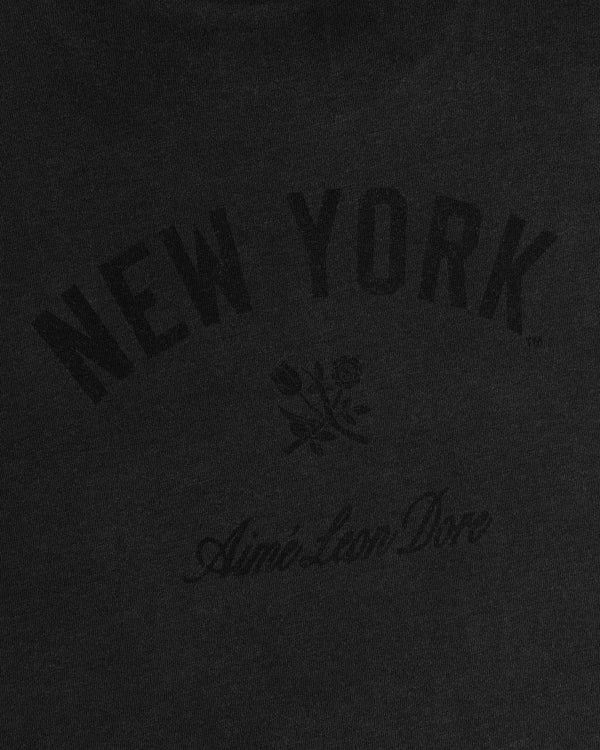 Black tee with arched NEW YORK, small rose, and cursive Aimé Leon Dore text. Yankees Washed Logo Tee.