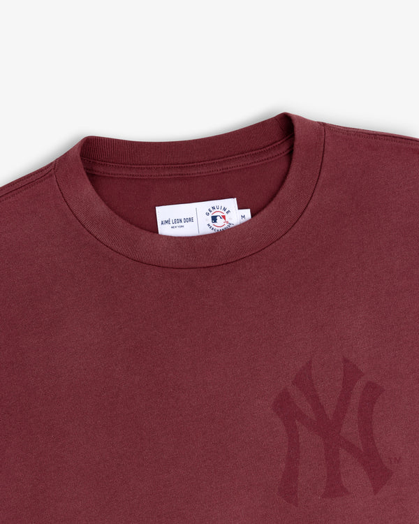 Close-up of a Yankees Washed Logo Tee in maroon, featuring a subtle logo and visible collar labels.