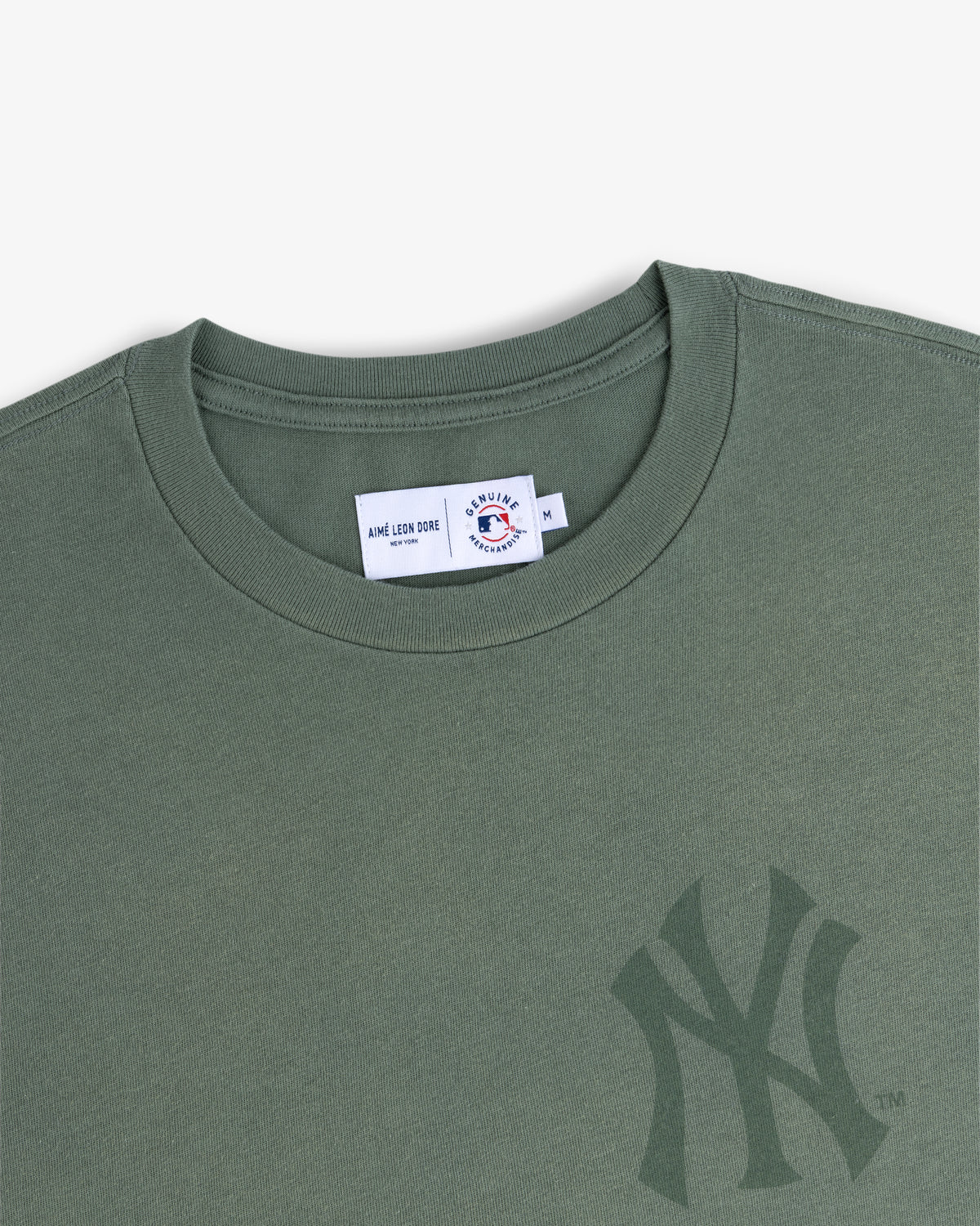 Yankees Washed Logo Tee in green with a subtle Yankees logo and visible neck tag inside the collar.