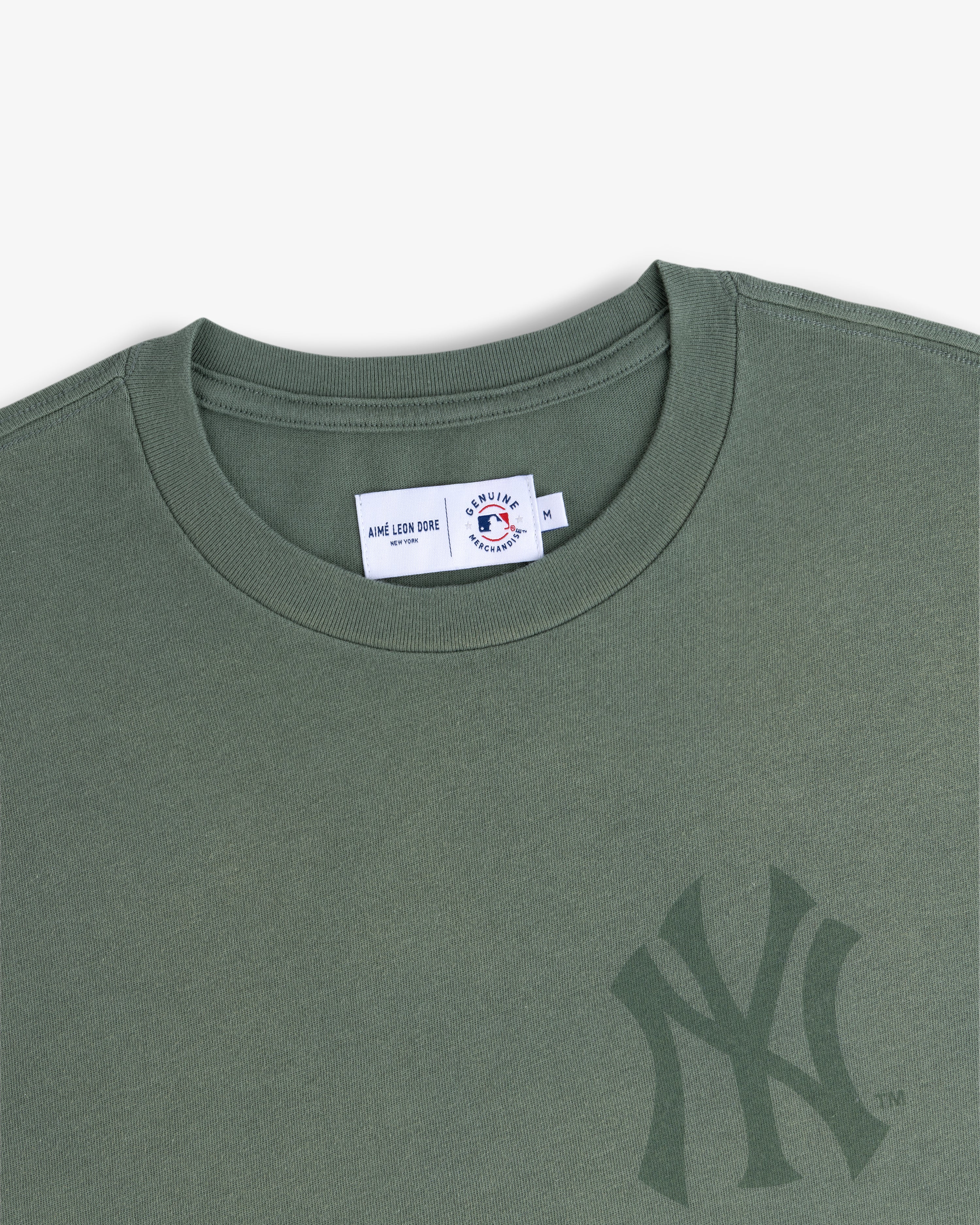 Yankees Washed Logo Tee in green with a subtle Yankees logo and visible neck tag inside the collar.