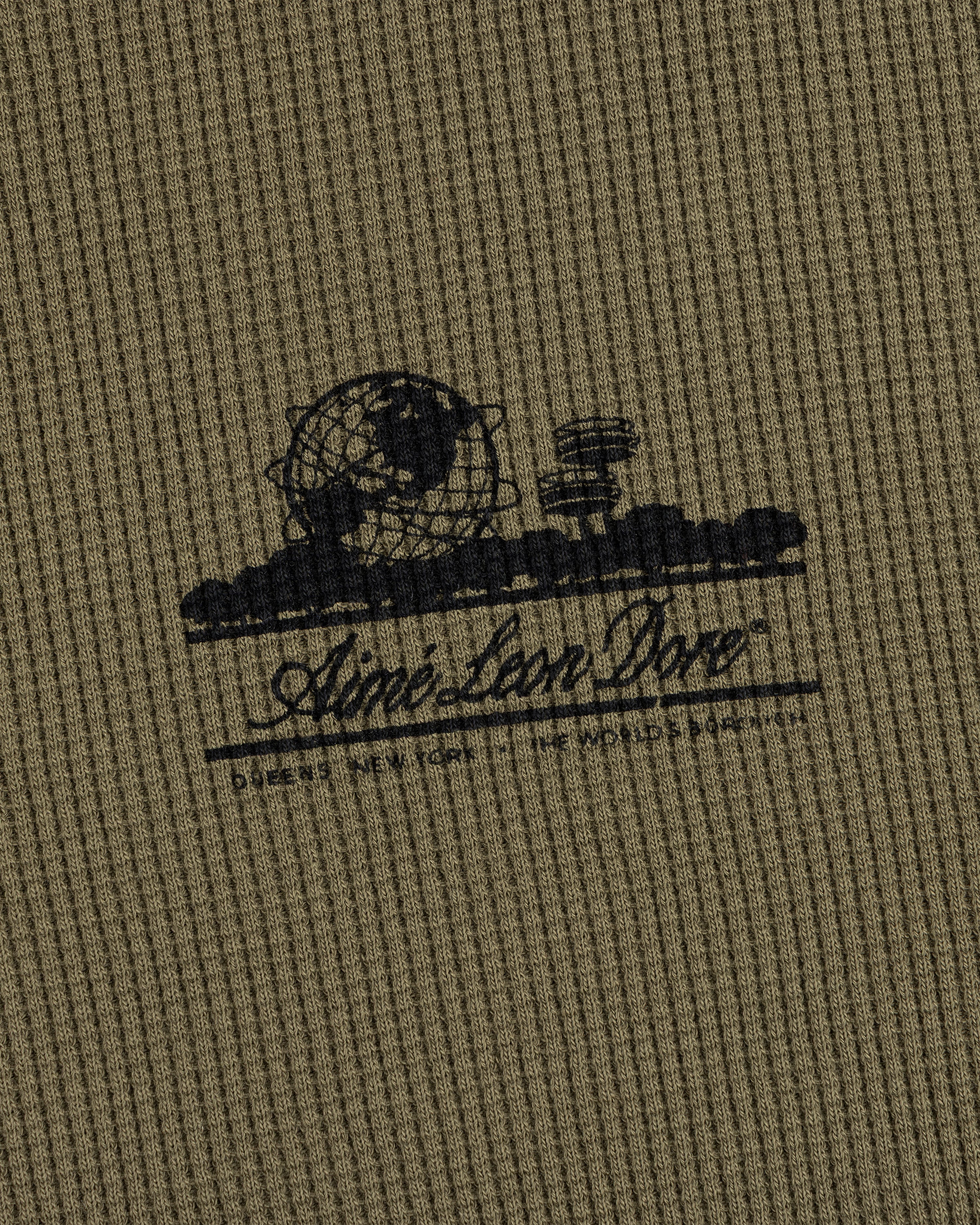 Olive Long-Sleeve Unisphere Waffle Thermal with a black globe, landscape print, and Ainé bon Doré cursive text.