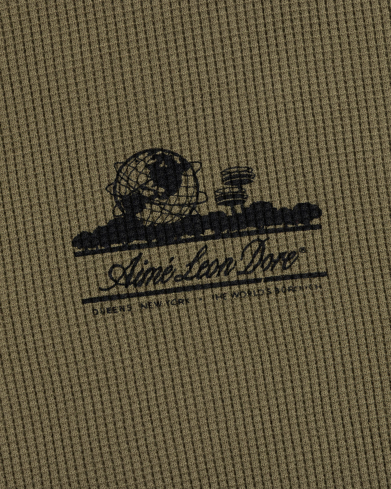 Olive Long-Sleeve Unisphere Waffle Thermal with a black globe, landscape print, and Ainé bon Doré cursive text.