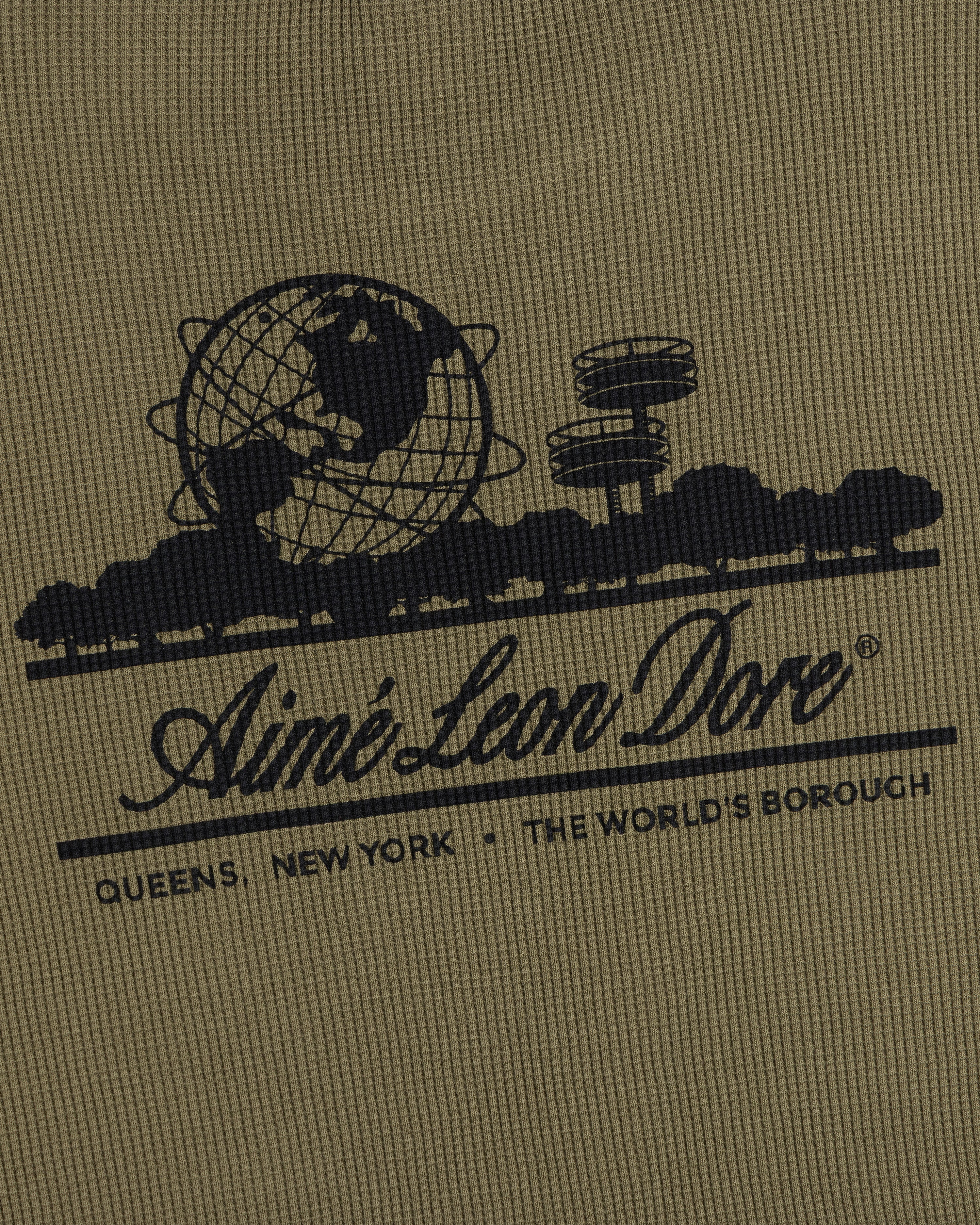 Black globe and building graphic with text on khaki Long-Sleeve Unisphere Waffle Thermal by Aimé Leon Dore.