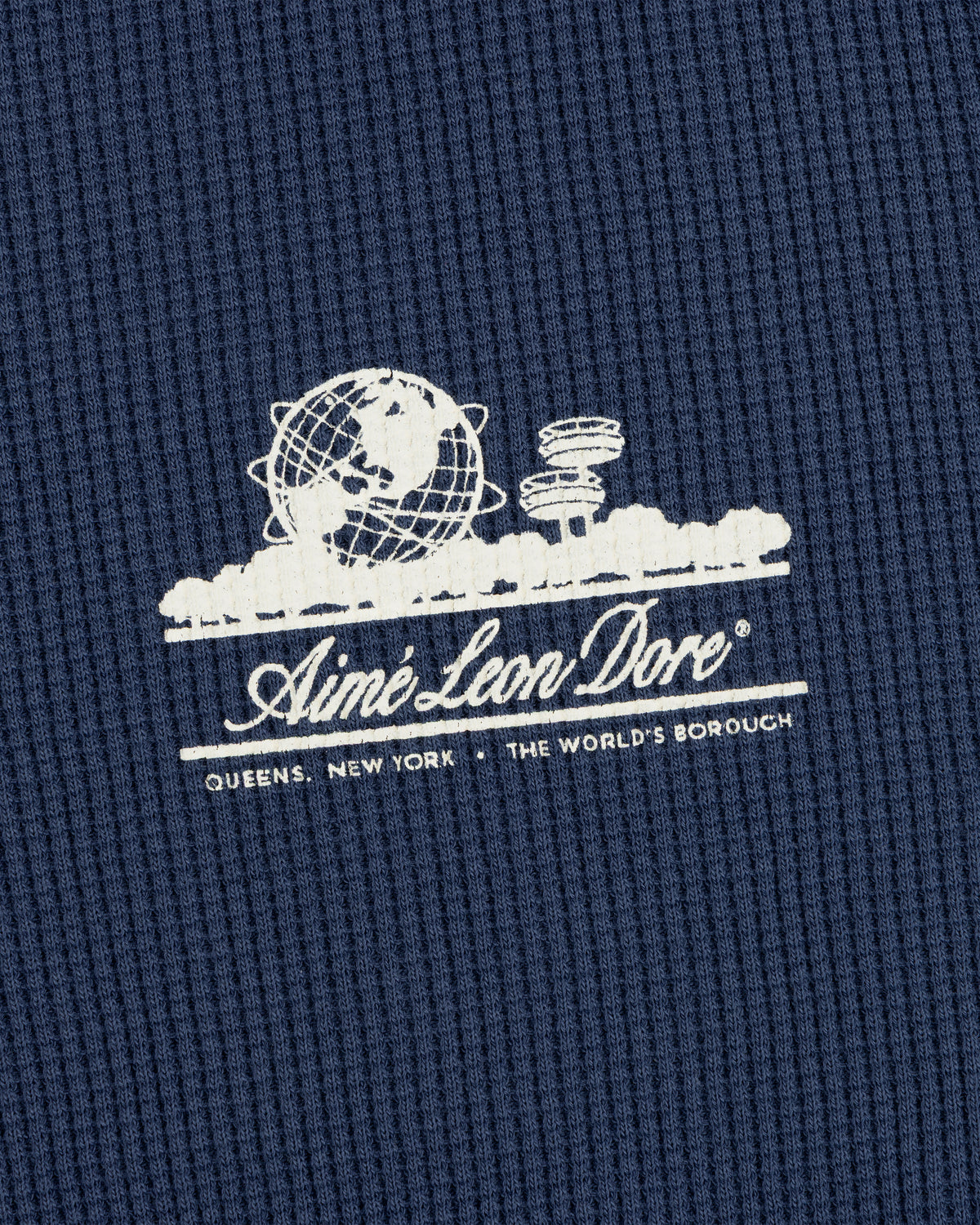 White Aimé Leon Dore Unisphere logo and Queens, NY text on blue Long-Sleeve Unisphere Waffle Thermal.