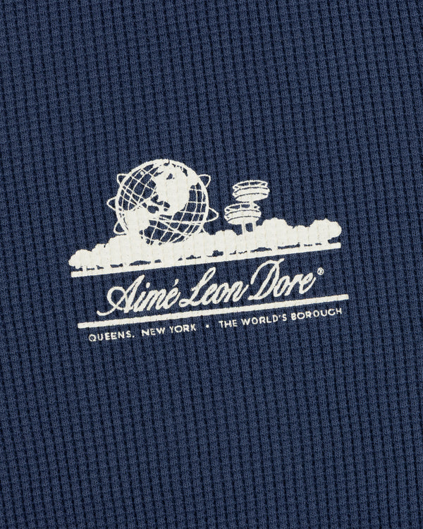 White Aimé Leon Dore Unisphere logo and Queens, NY text on blue Long-Sleeve Unisphere Waffle Thermal.