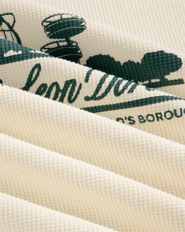 Close-up of Long-Sleeve Unisphere Waffle Thermal, cream-colored with green print visible between fabric folds.