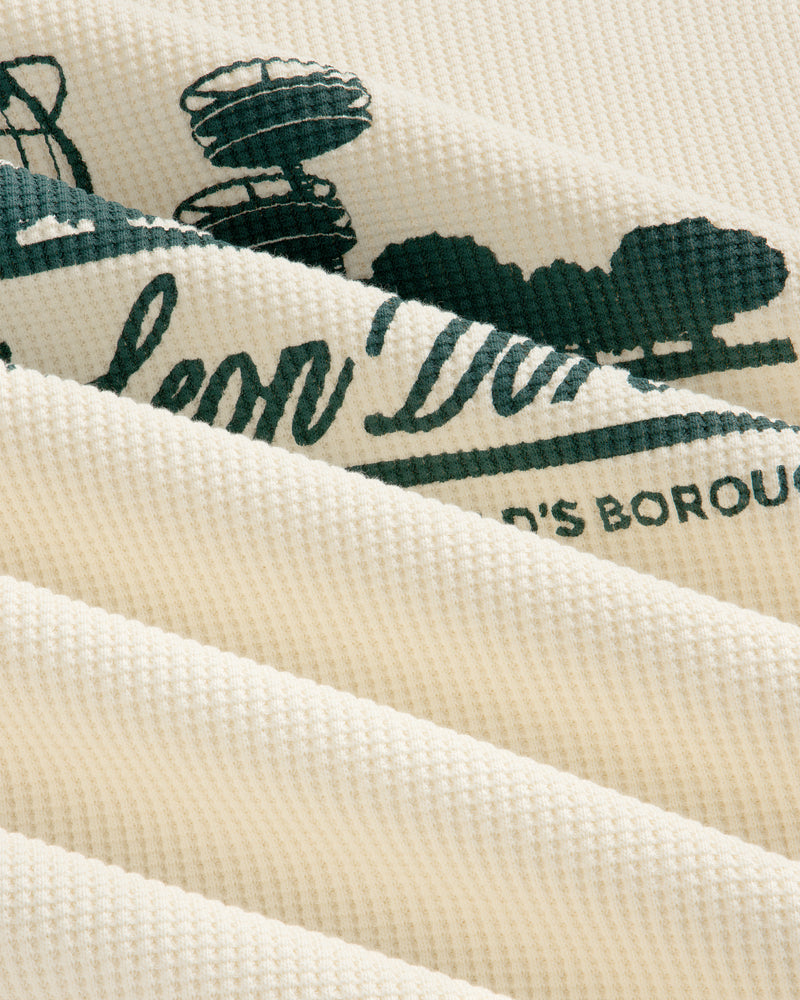 Close-up of Long-Sleeve Unisphere Waffle Thermal, cream-colored with green print visible between fabric folds.