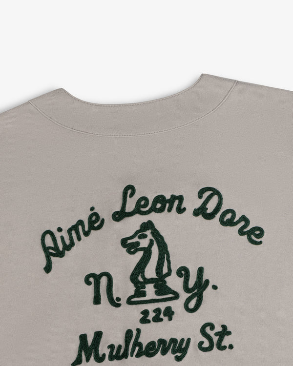 Beige Mulberry Chainstitch Baseball Jersey with green Aimé Leon Dore text, N.Y., 224 Mulberry, and chess knight.