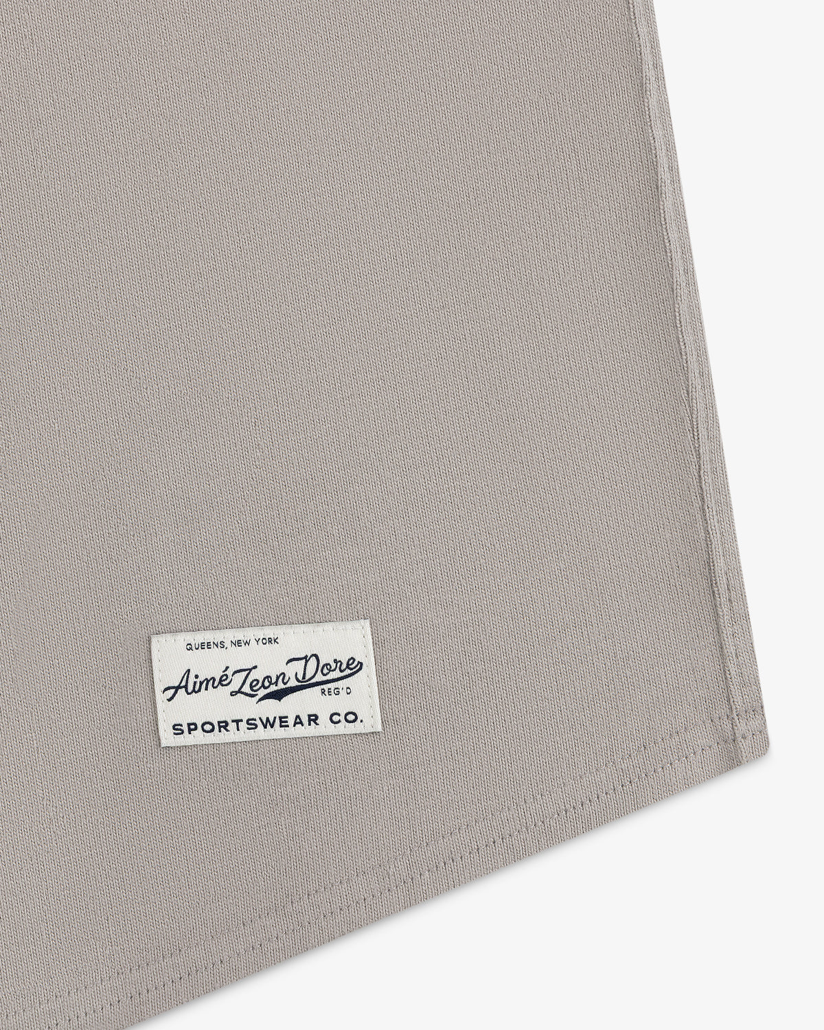 A close-up of a beige fabric corner with a Mulberry Chainstitch Baseball Jersey label sewn on.
