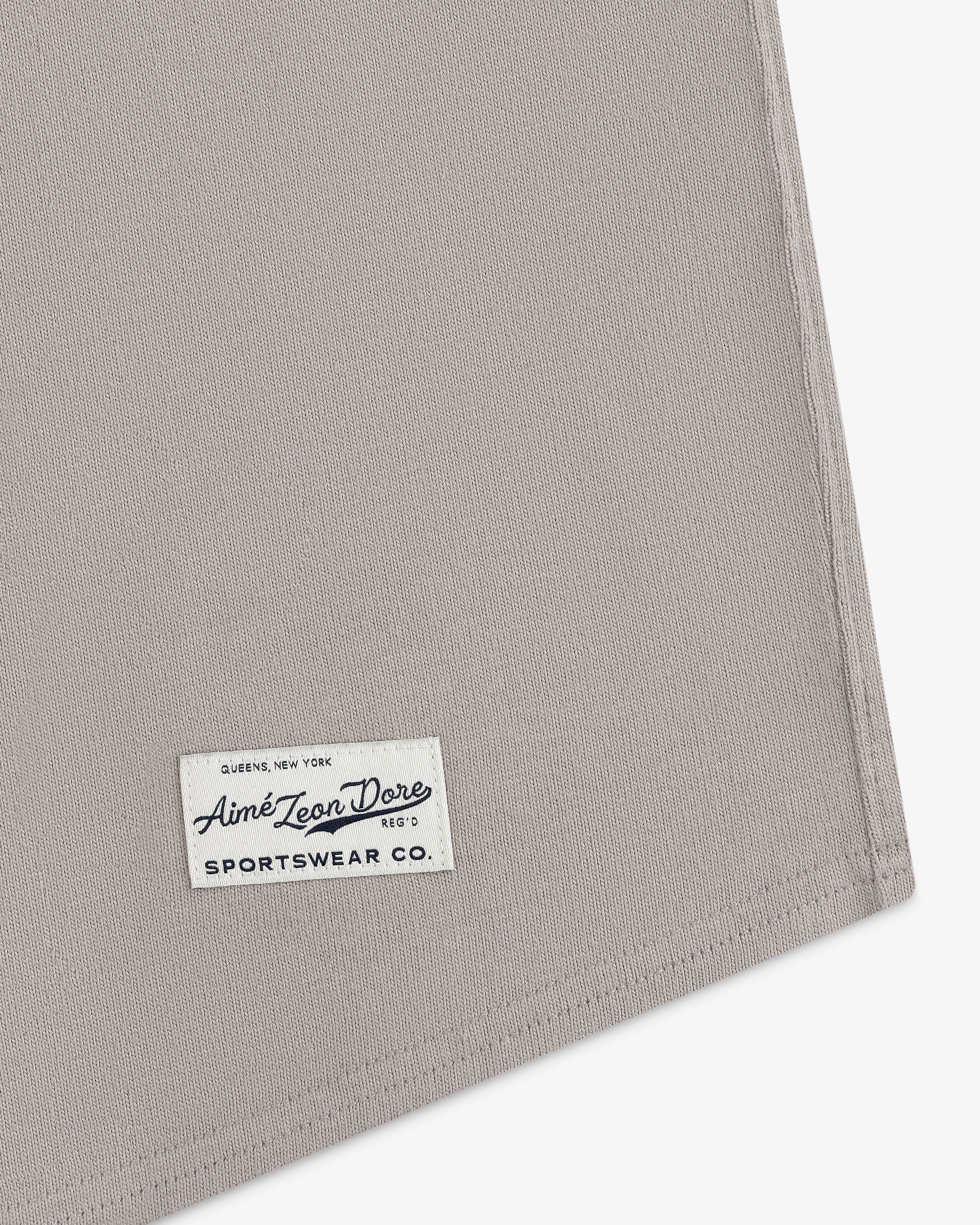 A close-up of a beige fabric corner with a Mulberry Chainstitch Baseball Jersey label sewn on.