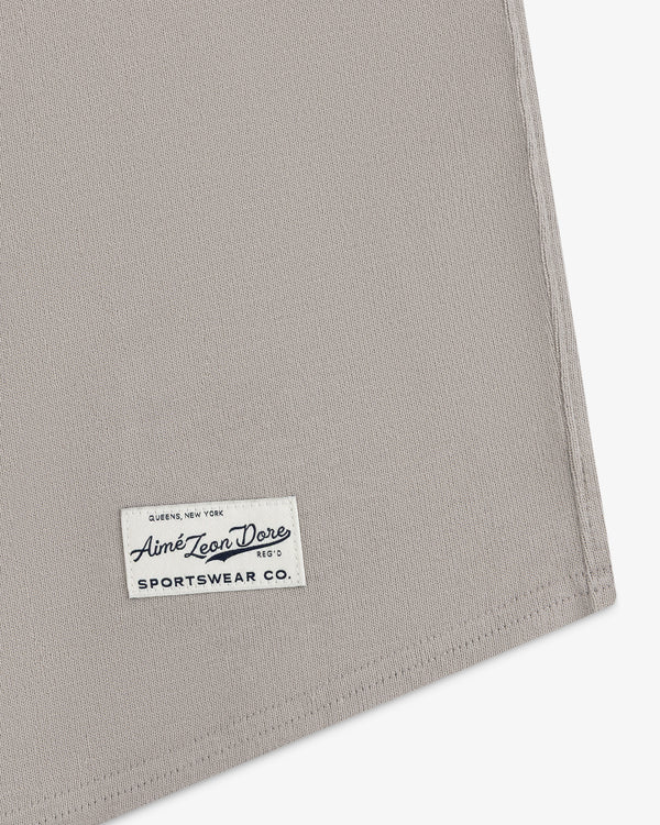 A close-up of a beige fabric corner with a Mulberry Chainstitch Baseball Jersey label sewn on.