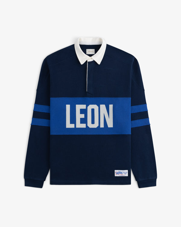 Leon Dore Collegiate Rugby: navy shirt, white collar, blue sleeve stripes, bold LEON logo across the chest.