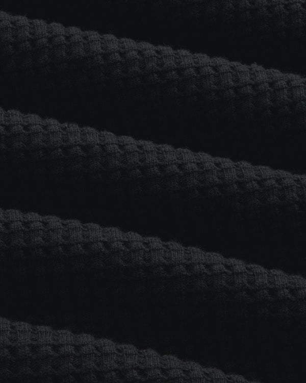 Close-up of black Long-Sleeve Waffle Thermal fabric with a textured waffle-knit pattern.