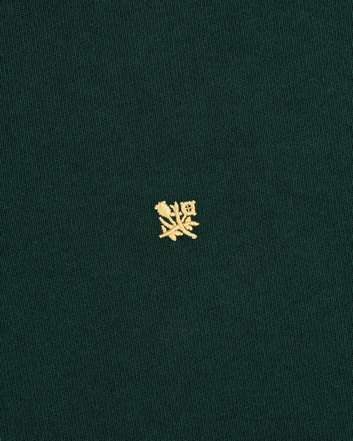 Crest Rugby: Green fabric with a small yellow embroidered crest design centered on the front.