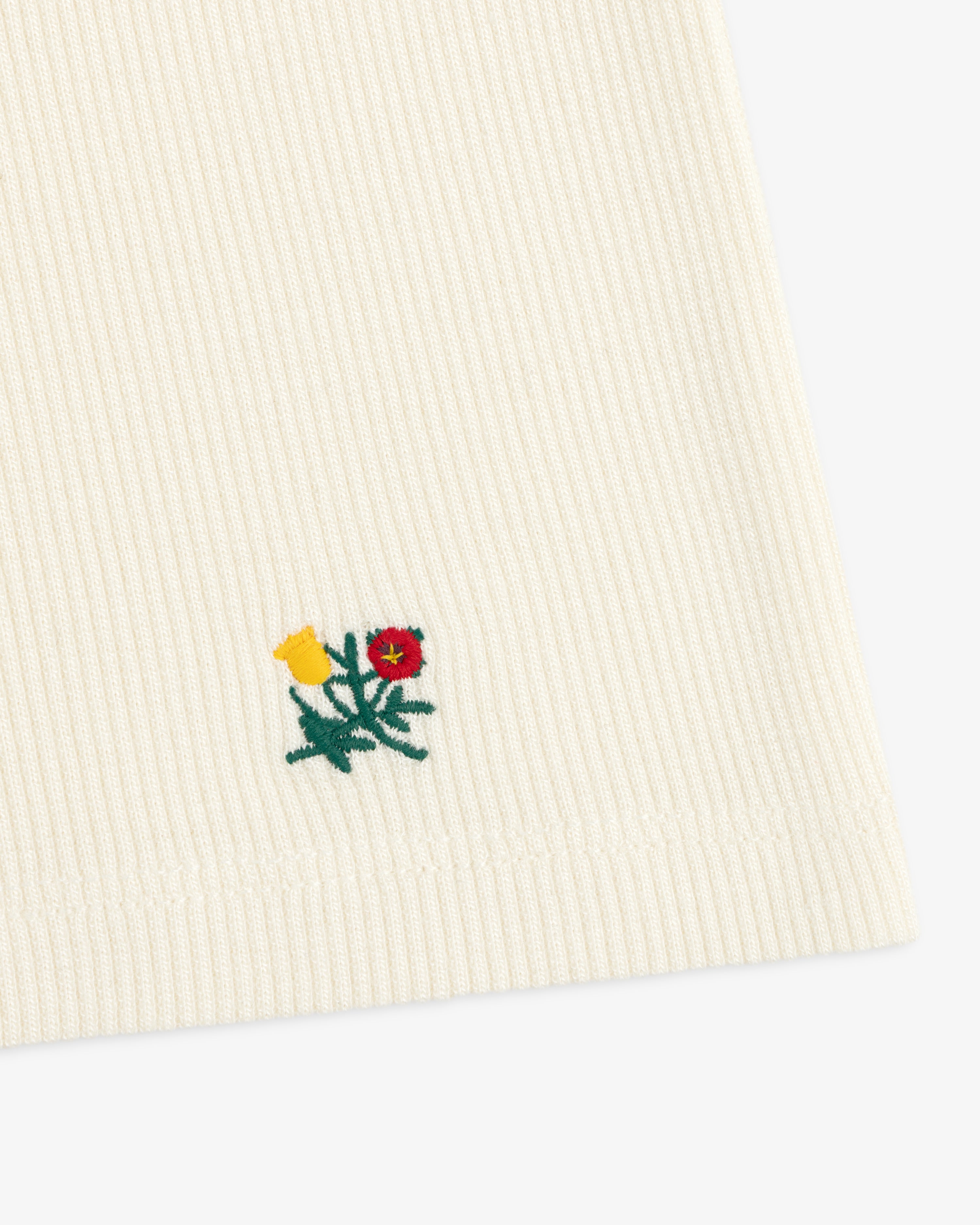 Cream-colored Ribbed Scoop Neck Long-Sleeve Tee with a small embroidered yellow and red floral design.