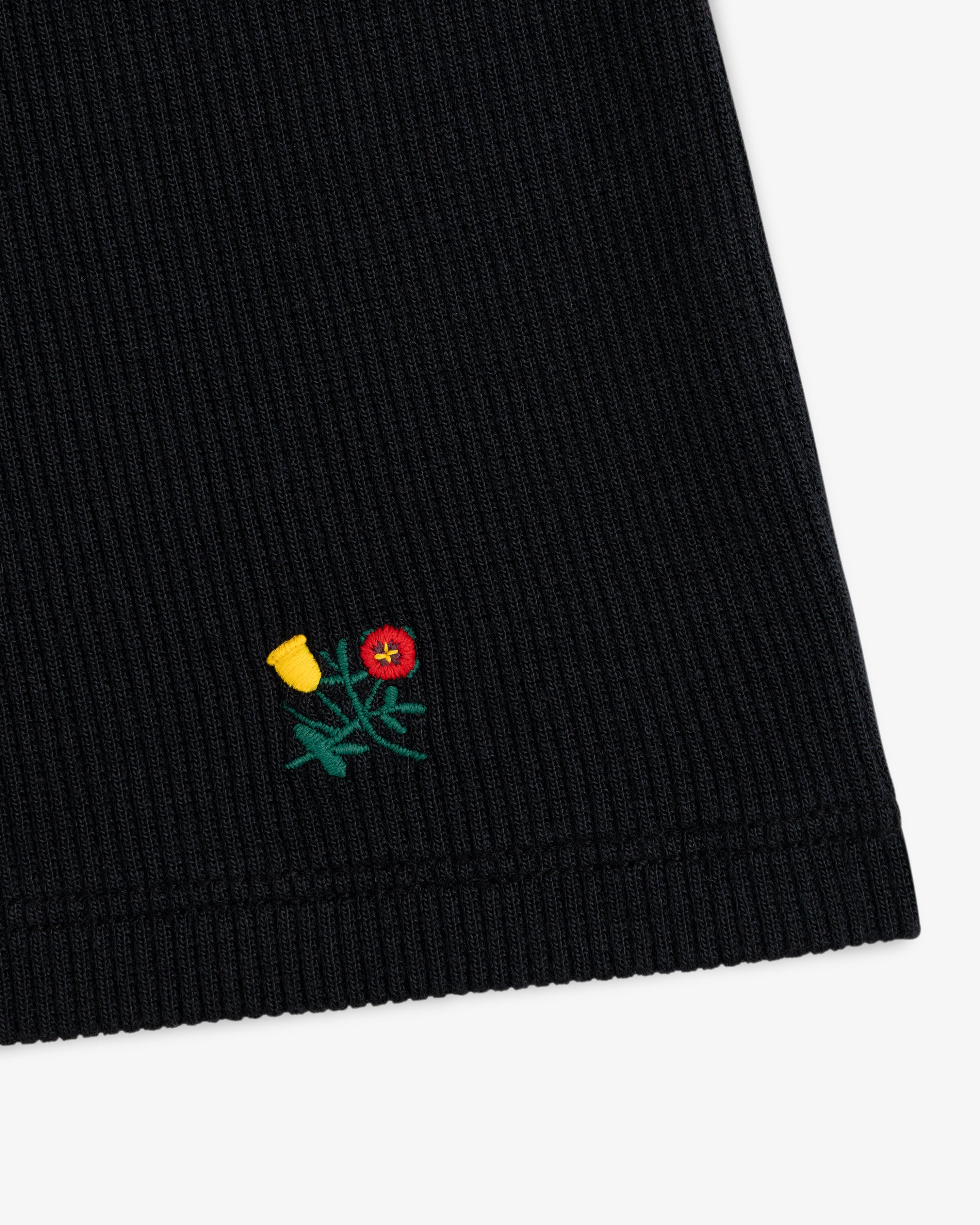 Black Ribbed Scoop Neck Long-Sleeve Tee with a small embroidered yellow and red flower near the hem.